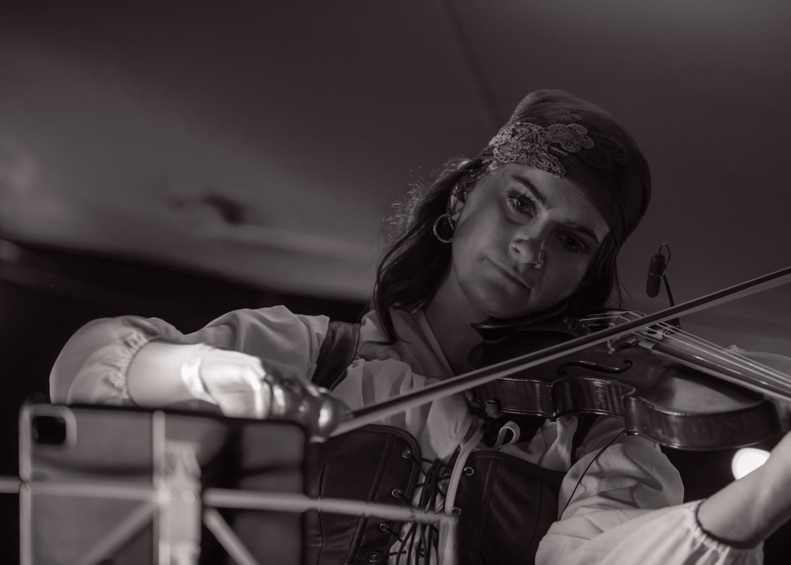 The violinist in a headscarf mid-song